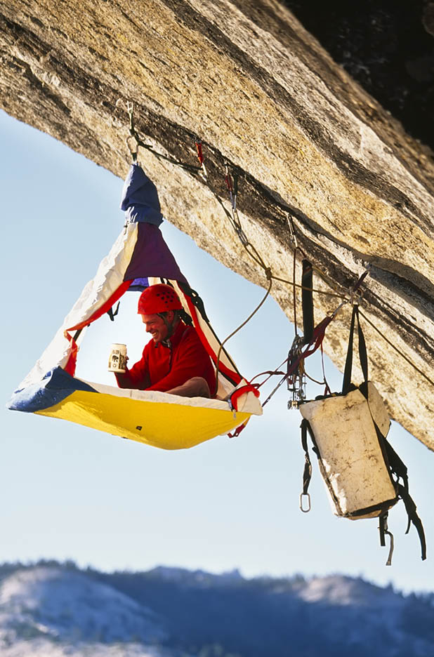 Rock climber bivouacked, portaledge on an overhanging cliff