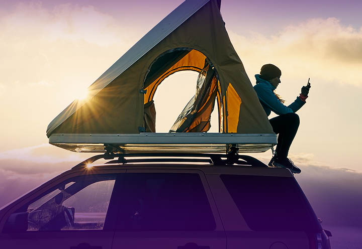 Woman on car with smartphone, Car camping