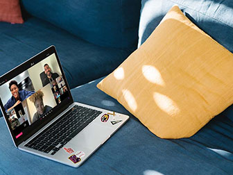 Laptop on the couch with REVEL sports fans interacting in a video conference